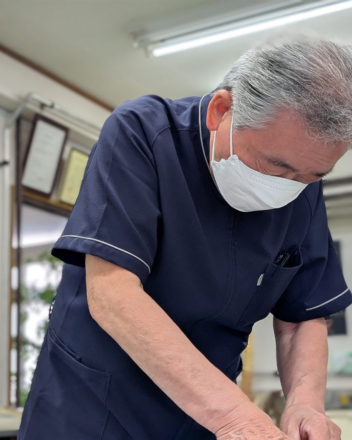 仁木治療院の施術者。トムソンテクニックによる施術を行っているところ